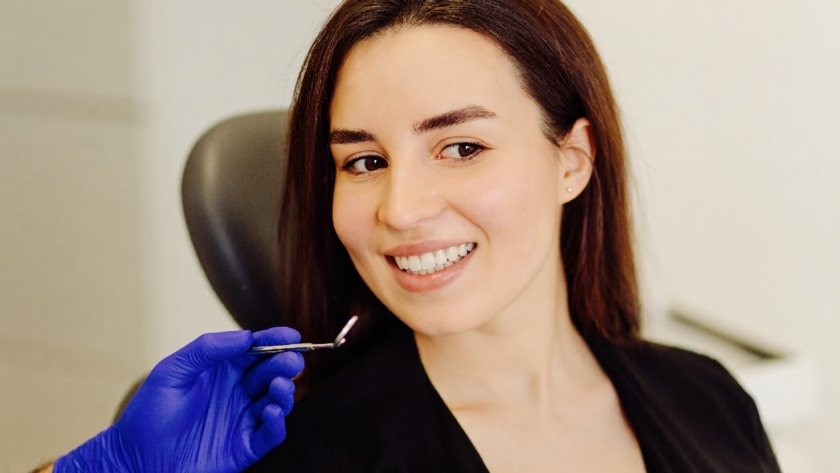 Patient smile after treatment for multiple missing teeth using ceramic bridge and flexible dentures