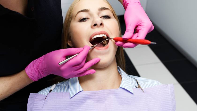 Dental implant evaluation in progress after gum disease treatment, showing a dentist examining a patient’s mouth during a dental checkup at a clinic