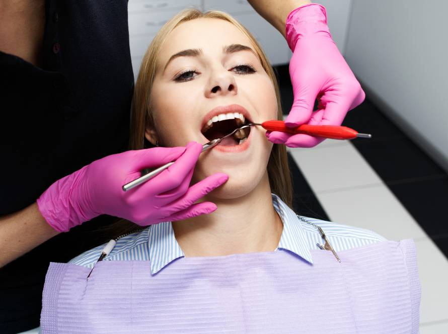 Dental implant evaluation in progress after gum disease treatment, showing a dentist examining a patient’s mouth during a dental checkup at a clinic