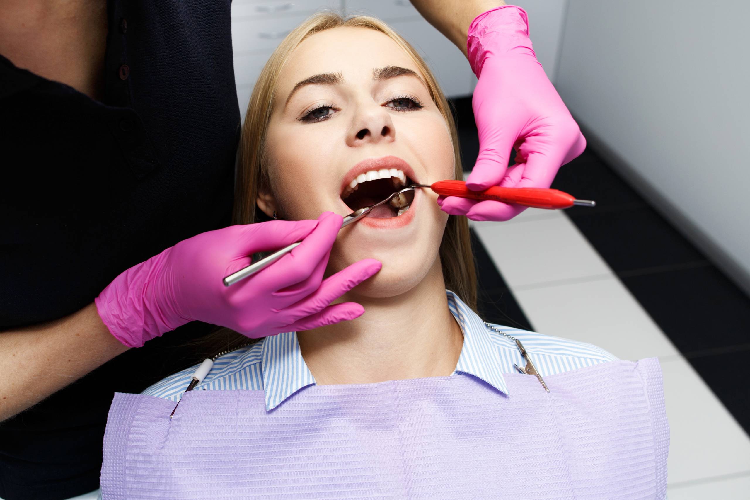 Dental implant evaluation in progress after gum disease treatment, showing a dentist examining a patient’s mouth during a dental checkup at a clinic